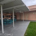 Blue tables and patio of the pool area of Ramrod Senior Housing, Inc.